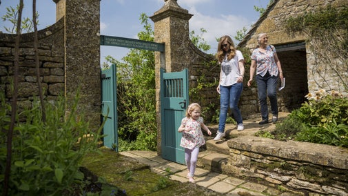 A child skipping down the steps with two family members